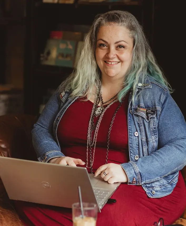 Carolyn smiling to camera with her laptop